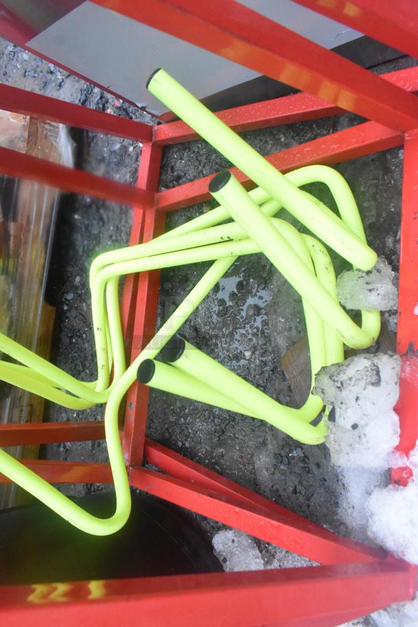 Forza red frame with black seat stool parts, disassembled, on icy ground. Condition: needs assembly. Potential outdoor furniture.