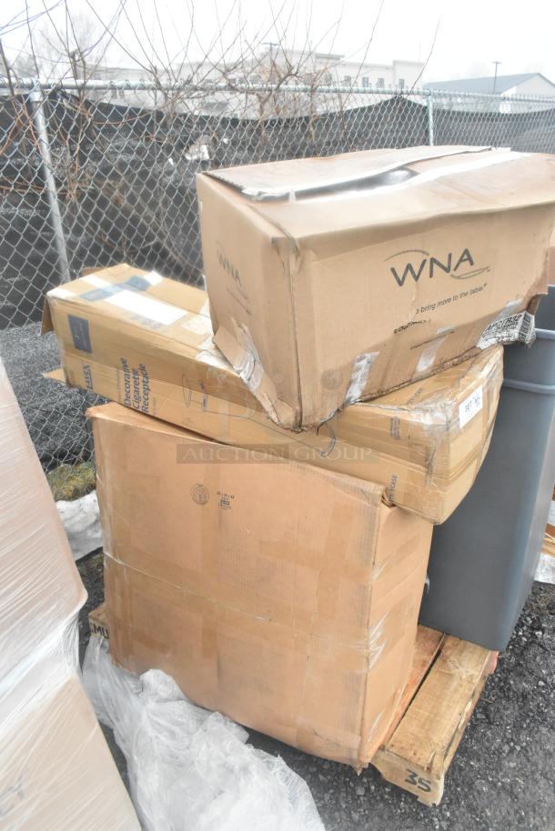 Stack of 13 brand new scratch and dent items, including trash cans, in original packaging. Boxes show wear. WNA branding visible.