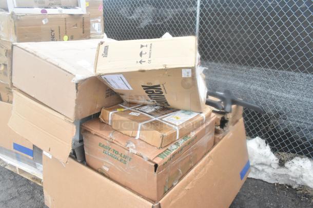 Pile of boxes including scratch-and-dent microwave shelves and table base pieces. Some wear visible on packaging.