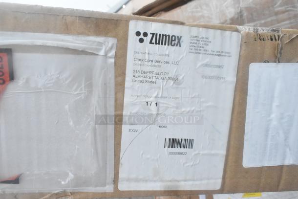 Box labeled "Zumex" with delivery address to Clark Core Services, Alpharetta, GA. Contains scratch and dent items.