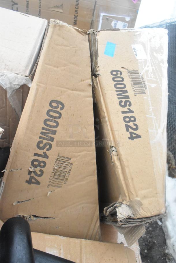 Two cardboard boxes marked "600MS1824" with visible wear, containing scratch and dent items, including microwave shelves and table base pieces.