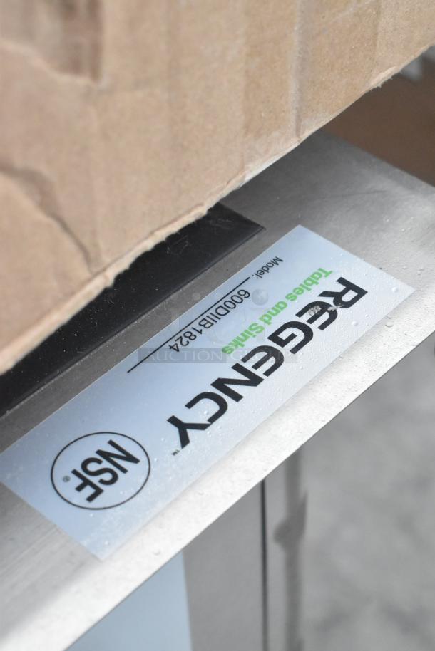 Alt text: Regency Tables and Sinks label on metal surface, Model 600DIB1824, showing slight water droplets.