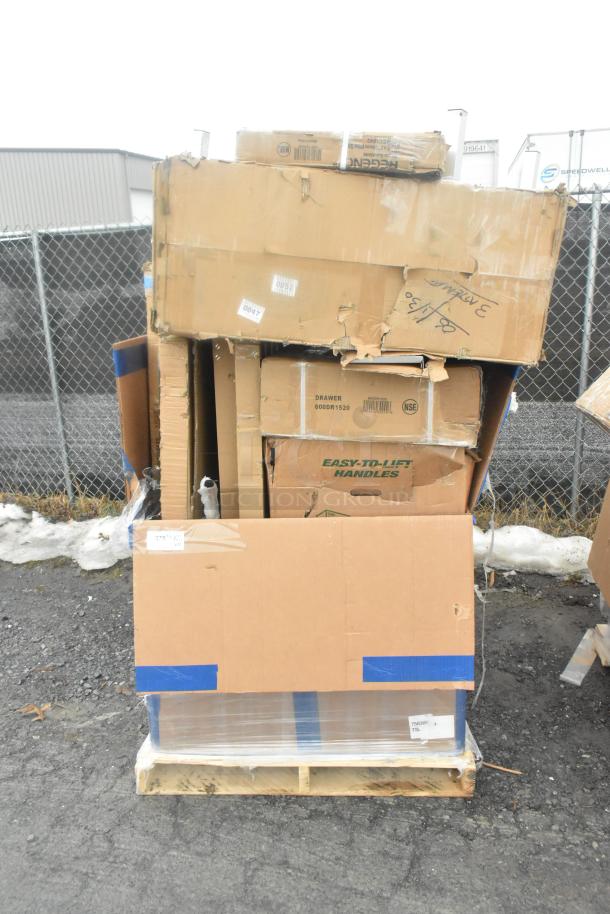 Stack of new, scratch and dent items including work tables and racks in damaged boxes on a pallet.
