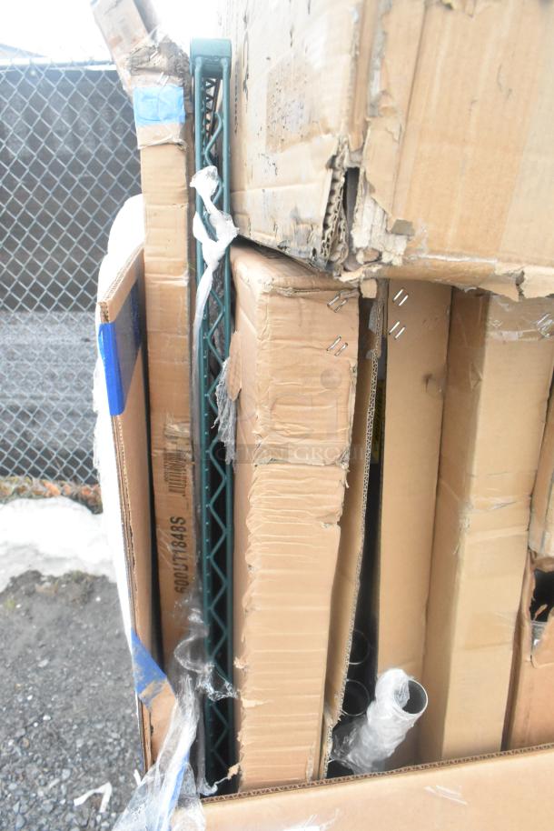 12 brand new scratch and dent items in boxes, including work tables, shelf, and dunnage rack. Boxes show wear.