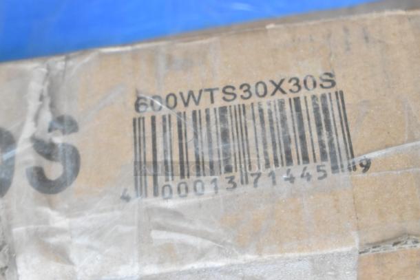 Cardboard box with barcode and code "600WTS30X30S," indicating a lot of new scratch-and-dent items.