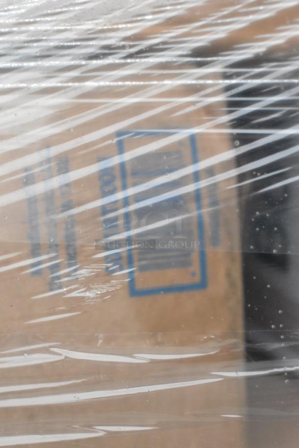 Plastic-wrapped box marked with barcode and text, possibly containing scratch and dent items like towels and portion cups.