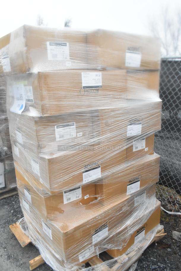 Stack of boxed items shrink-wrapped on a pallet, labeled with various tags. Items include Nappie bowls, mugs, and tiles.