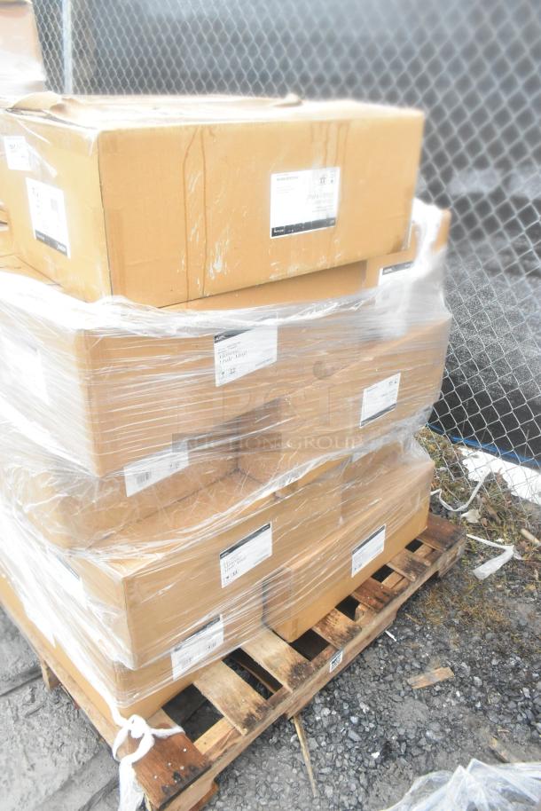 Stack of boxed items labeled "scratch and dent" on a wooden pallet, wrapped in plastic. Includes new mugs.