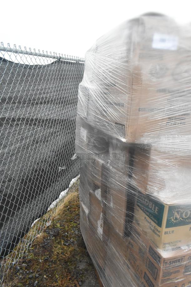 Plastic-wrapped pallet with boxes of scratch and dent items, including takeout containers and paper towels, stored outdoors.