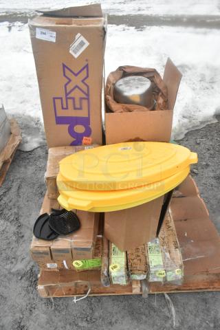 Pallet with assorted new scratch and dent items: FedEx box, yellow lid, oven rack, and packaging, outdoor setting.