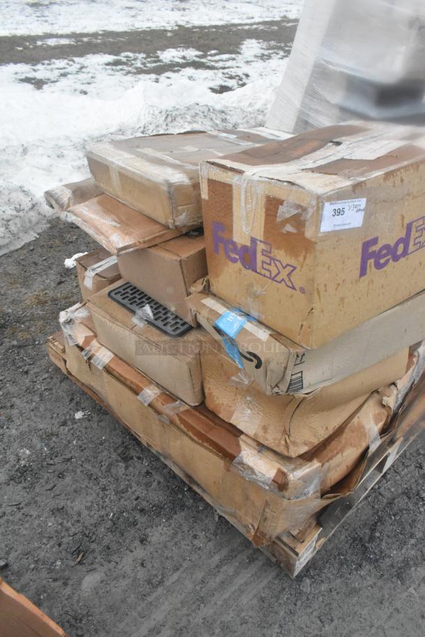Stack of boxed items, some labeled "FedEx," with visible signs of wear and tear, on a pallet outdoors.