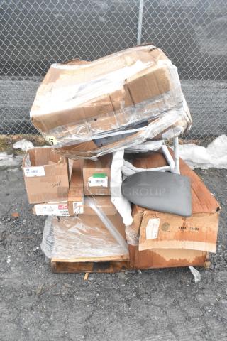Pallet of mixed new scratch and dent items including boxes of casters and posts, wrapped in plastic, outdoor setting.