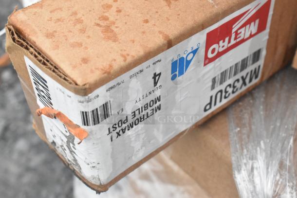 Cardboard box of MetroMax i Mobile Post with visible wear, labeled "Quantity 4," and slight water stains, part of scratch and dent auction set.