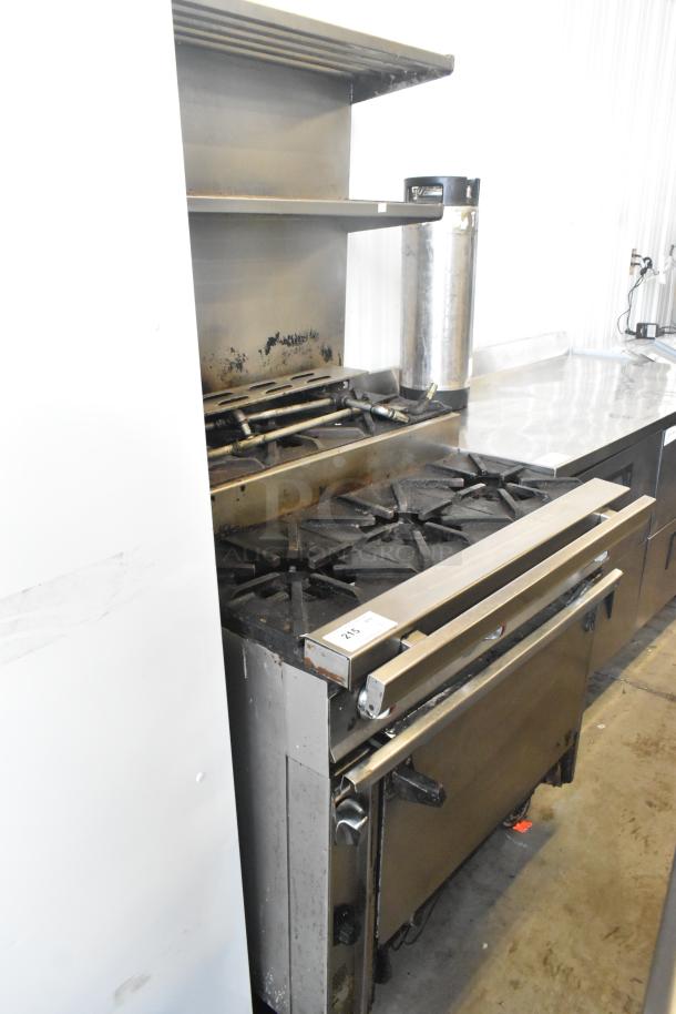 Commercial gas-powered 6-burner range with oven, over shelf, and backsplash on casters. Used condition, tag marked "215".