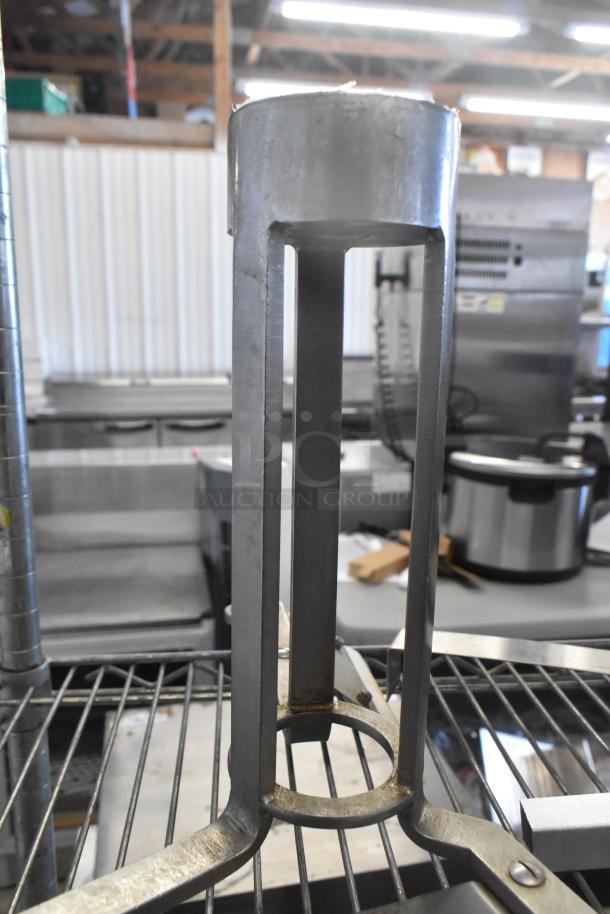 Metal auger with cylindrical design, sturdy metal construction, slight surface wear, ideal for industrial use.