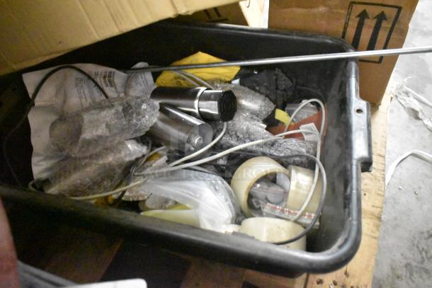 Box of mixed items including receipt printers, hardware, and table legs. Items wrapped in bubble wrap and packing materials.