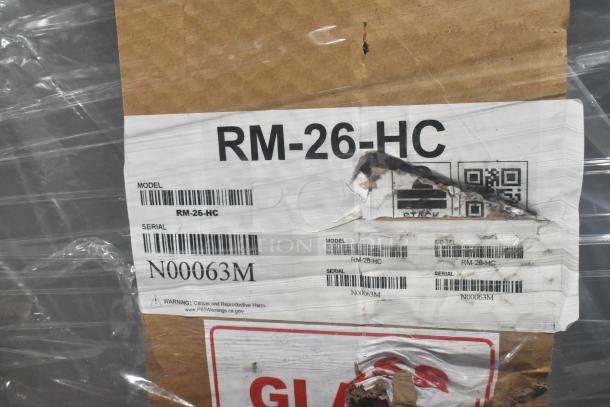 Label on a Hoshizaki RM-26-HC cooler box showing model and serial numbers, with visible scratches and dents.