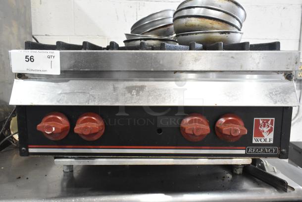 Wolf commercial countertop gas-powered range with 4 burners. Features red knobs, Wolf logo, and visible wear. Auction tag No. 56.