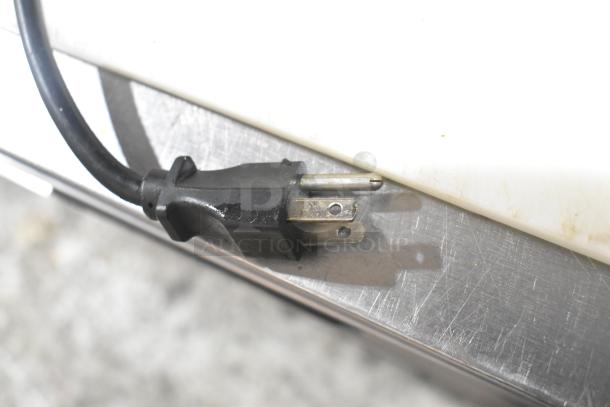 A close-up of the power plug for a Delfield commercial sandwich salad prep table, indicating 115 volts, 1 phase.