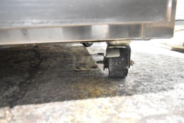 Delfield commercial cooler with 4 half-size doors, shown on durable commercial casters.