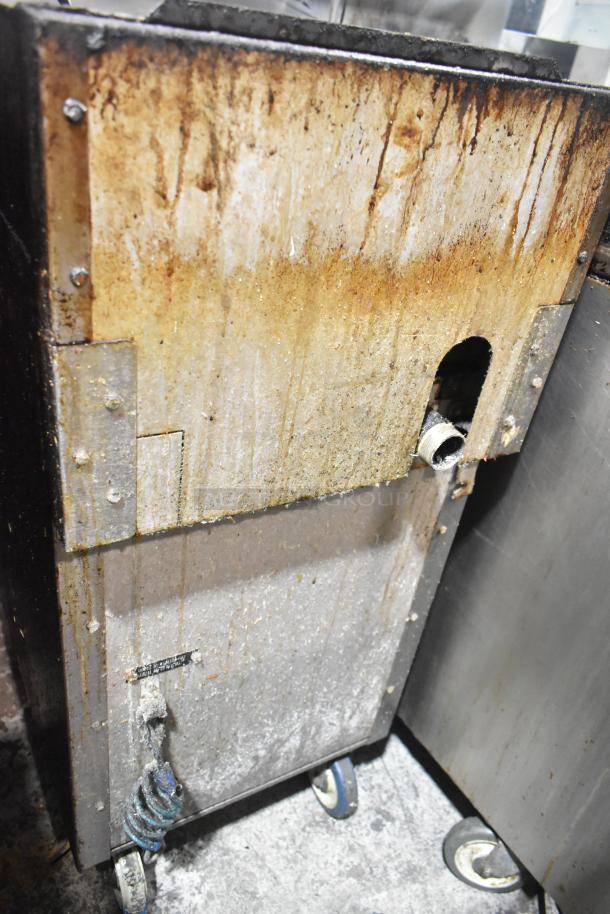 Vulcan VGM18B commercial gas griddle, 80,000 BTU, on casters, worn condition, visible rust and grime, lower cabinet visible.