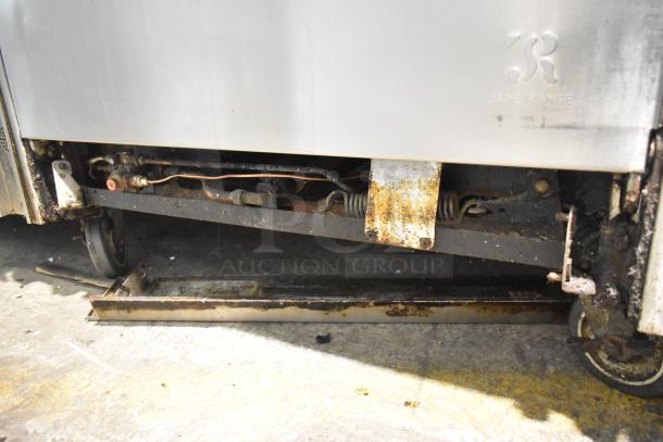 Commercial gas-powered 12-burner range with 2 ovens, over shelf, backsplash, commercial casters. Worn condition, Jade Range logo visible.