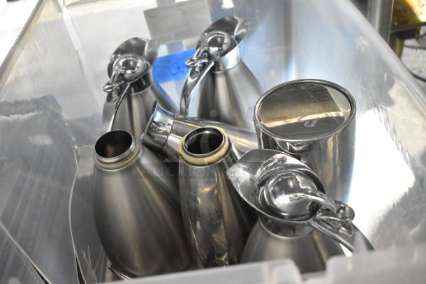 Alt text: Lot of metal carafes in a plastic container, shiny finish, varying sizes, used condition, ideal for kitchen use.