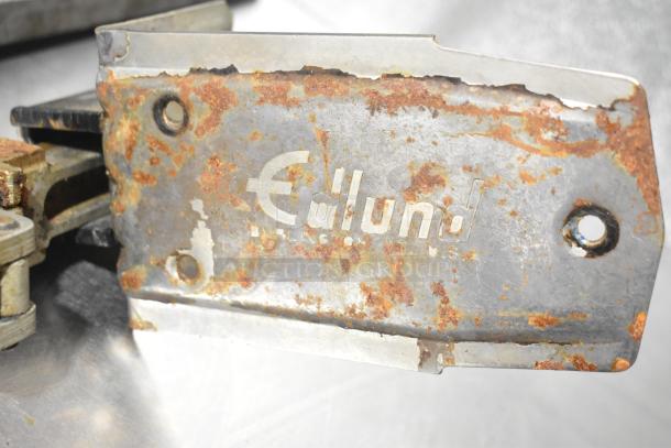 Two rusted Edlund commercial can openers with a mount, showing signs of wear, model text partially visible.