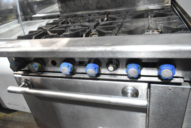 Imperial commercial gas 6-burner range with salamander cheese melter and oven. Features durable construction, used condition.