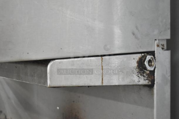 Imperial Commercial Gas 6-Burner Range with Salamander Cheese Melter and Oven. Visible wear and staining on metal surface.