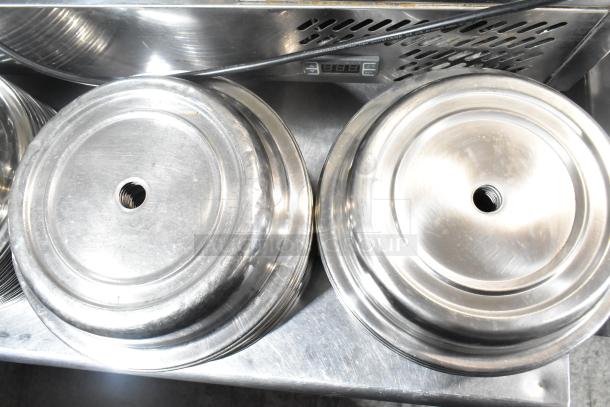 Set of 98 metal dome covers with center holes, silver finish, used condition, ideal for catering or kitchen use.
