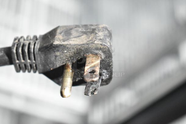 Damaged electrical plug of the Entree CF1-S commercial freezer. Note exposure and wear on prongs; requires replacement.