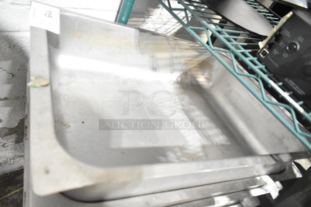 Set of 5 stainless steam pans and 1 server countertop 4 well holding bin, used condition, visible scratches and wear.