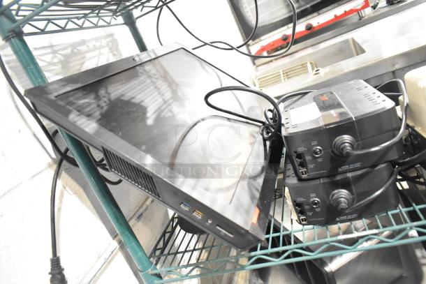 Three-item lot: two APC uninterruptible power supplies and a ThinkCentre monitor. Used, visible cables, positioned on a shelf.