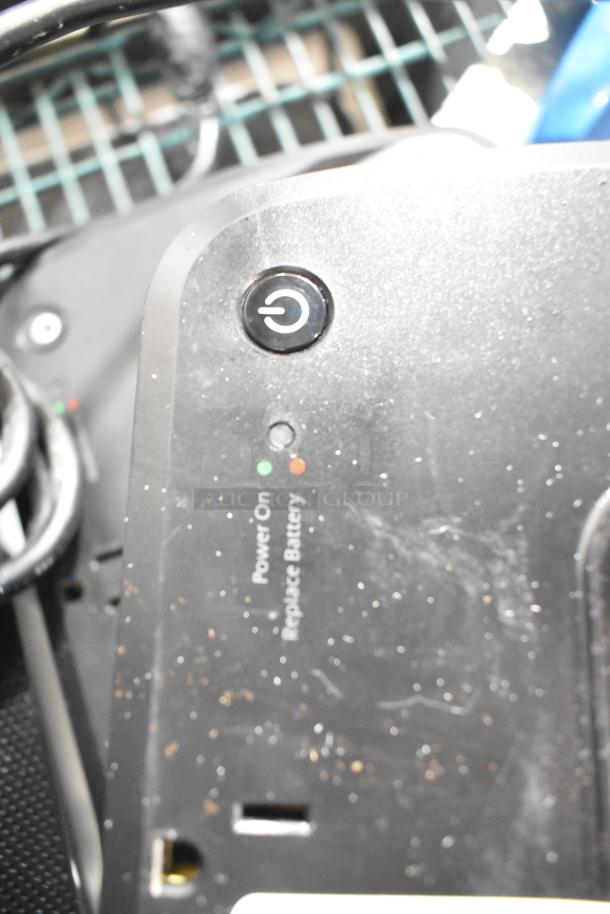 APC uninterruptible power supply showing power and battery status indicators. Surface shows dust and wear.