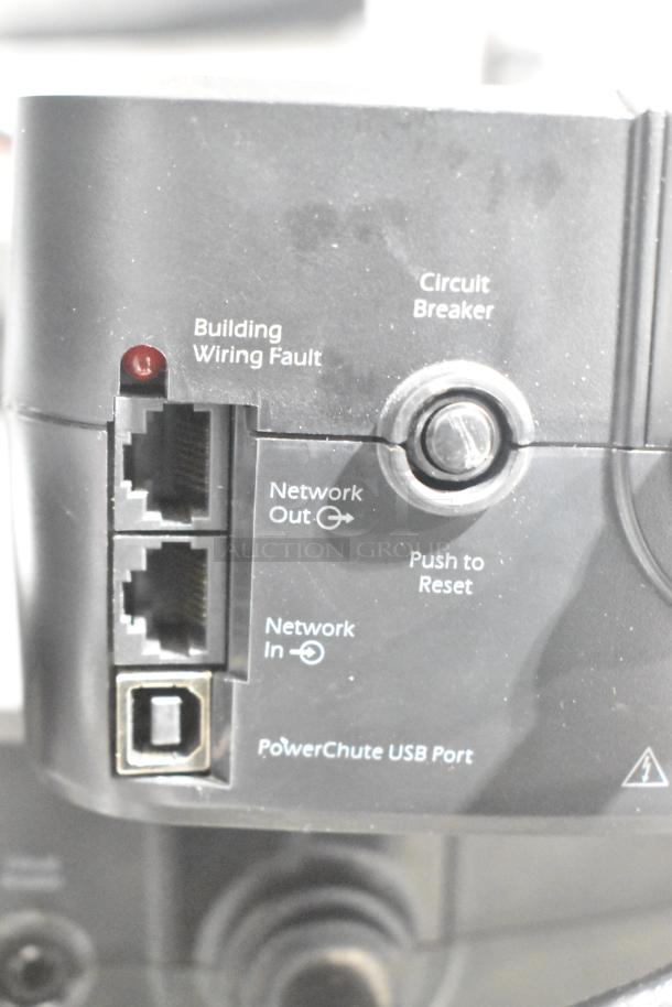 APC Uninterruptible Power Supply close-up, showing circuit breaker, network ports, reset button, and USB port.