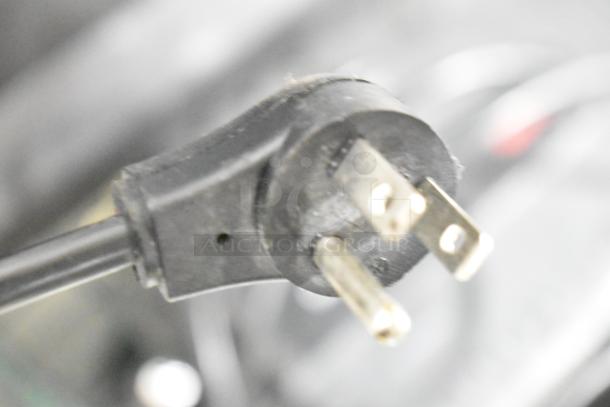 Close-up of a black power plug likely part of APC UPS unit, with visible prongs and slightly worn condition.