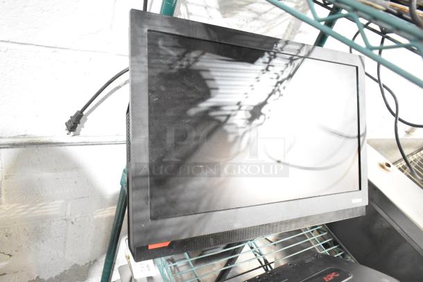 3 items: ThinkCentre monitor and two APC uninterruptible power supplies on a shelf. Monitor in used condition.