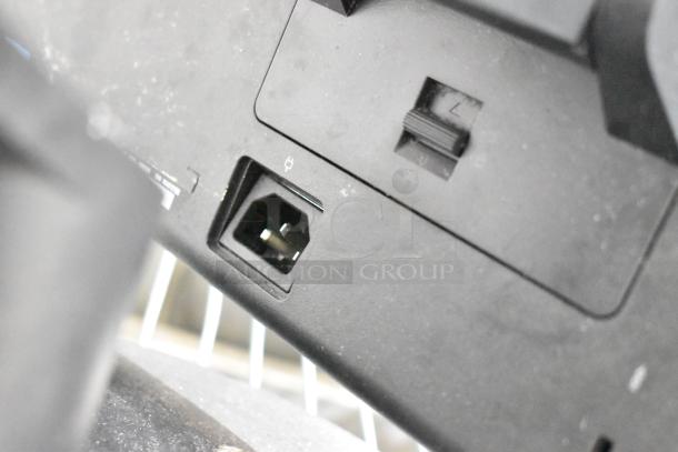Close-up of APC Uninterruptible Power Supply power port and adjacent switch. Black finish, showing minor wear.