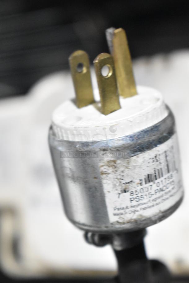 Close-up of a VCMA-20ULST pump plug with visible barcode. 115 volts, 1 phase. Slight wear on the metal casing.