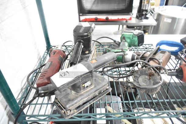 Various tools including a Black & Decker sander, Hitachi cordless impact driver, and more on a metal shelf. Visible tag "121."