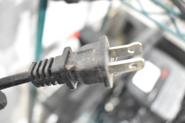 A close-up of a standard two-prong electrical plug in used condition, likely from one of the listed auction items.