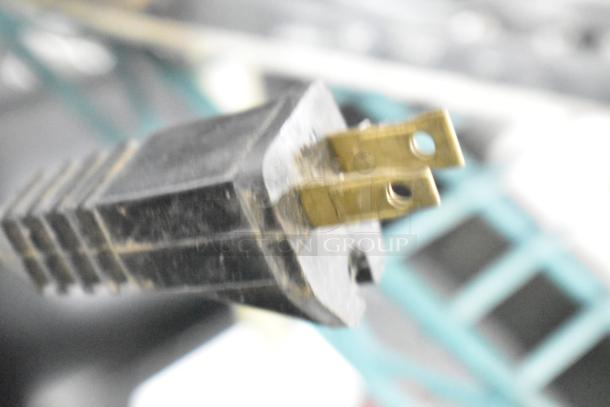 Plug end of a power tool featured in an auction lot of eight items, including various sanders and drills.