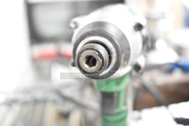 Close-up of a tool, possibly part of the 8-item set including Hitachi cordless impact driver, showing metal front and used condition.