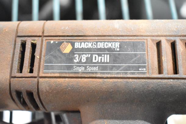 Black & Decker 3/8" single speed drill, visible wear, part of auction lot including tools like sander and impact driver.
