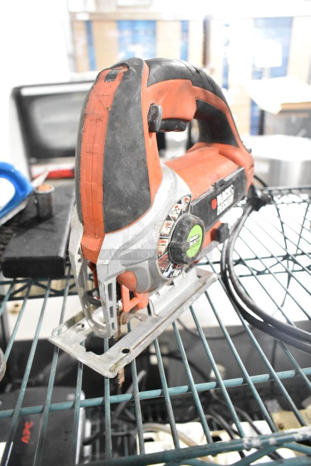 Black and Decker saw on shelf, featuring a red and black handle, heavy-duty design, appears in used condition.