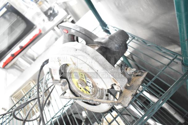 Skilsaw saw with visible wear, placed on a metal shelf. Suitable for various cutting needs.