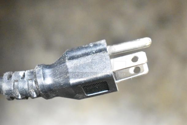 Close-up of a 115V power plug for a 2023 Motak MSD-1DF-BAL-19-X commercial freezer. Black cable, three-prong design.