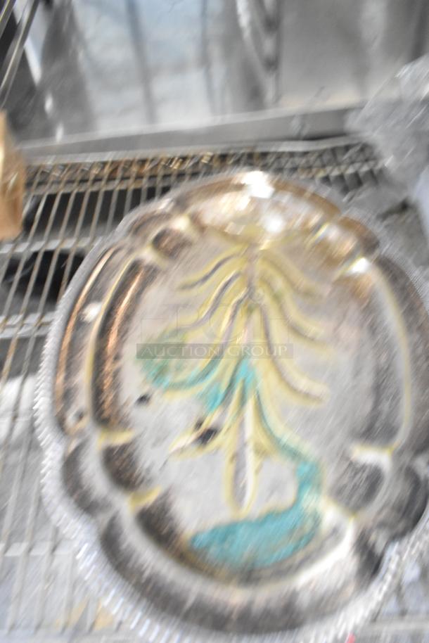 Blurry image of a decorative metal tray with colorful design and scalloped edges. Scratch and dent visible.