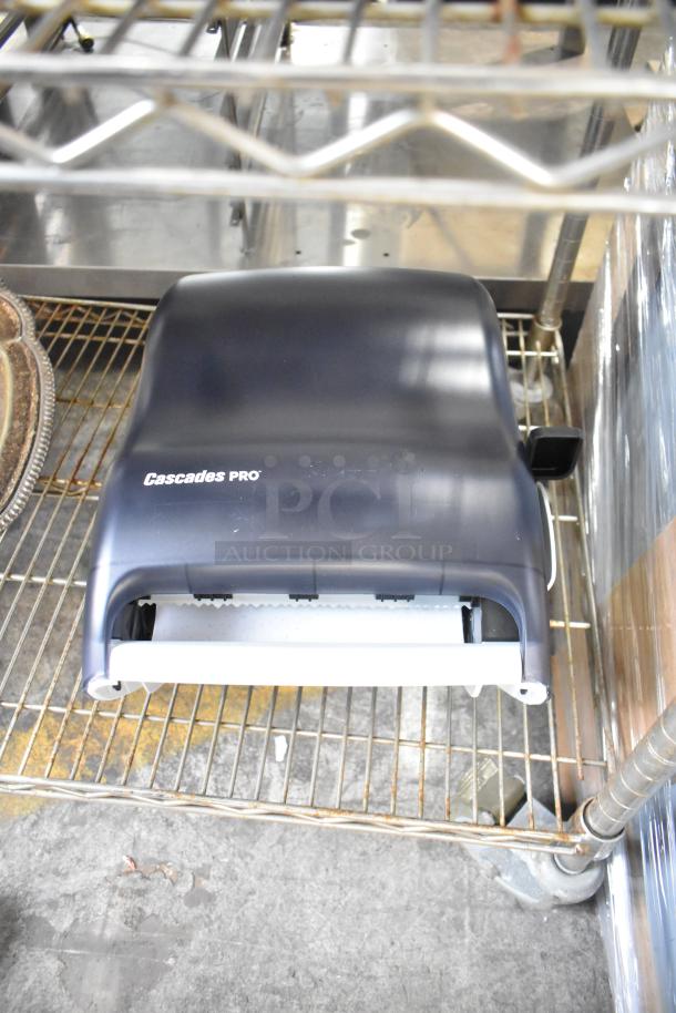 Cascades PRO paper towel dispenser, new condition, on metal shelf.